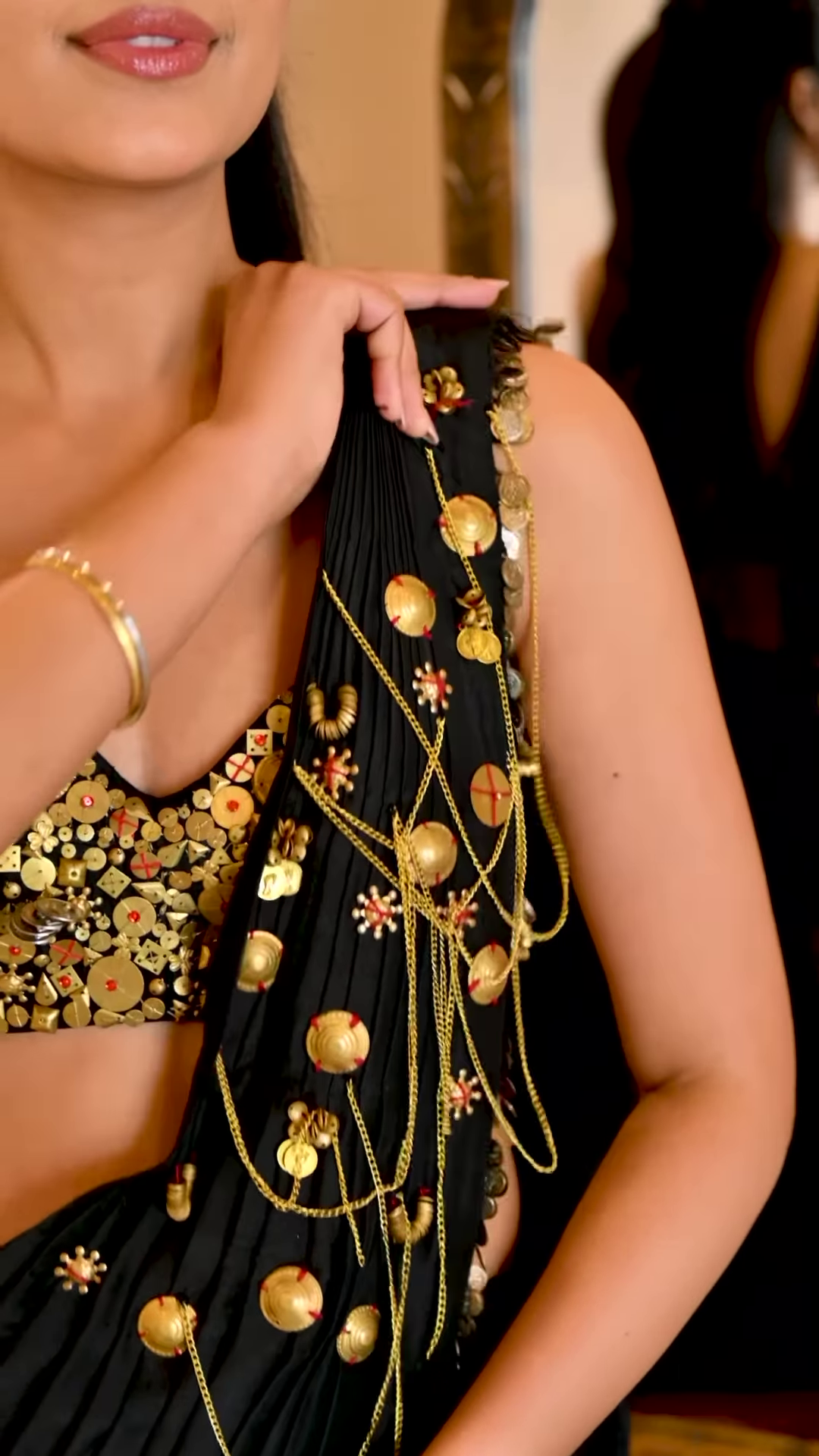 Women’s Black Saree with Gold Embellishments & Pleated Draping – Elegant Ethnicwear Styled with Traditional Bracelet